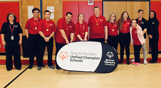 The+Bocce+team+poses+for+a+photograph+with+the+Special+Olympics+banner+coming+away+from+their+championship+win.