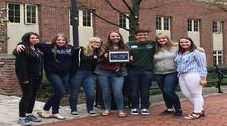 The students hold their plaque and smile for a picture to show their success.