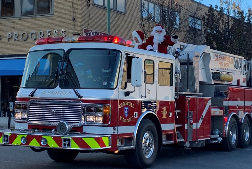 Mr. and Mrs. Claus come to town riding on a fire truck.
