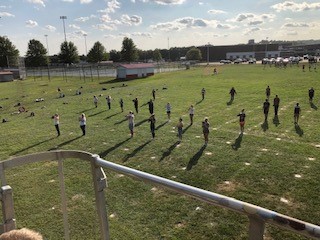 Marching band practicing their half-time show. performance