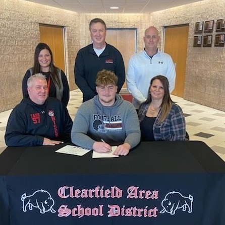 Zane Inguangiato, seated at center, poses with his parents as the following look on, standing from left: Principal Mrs. Prestash, Football Coach Mr. Janocko, and Athletic Director Mr. Gearheart.
