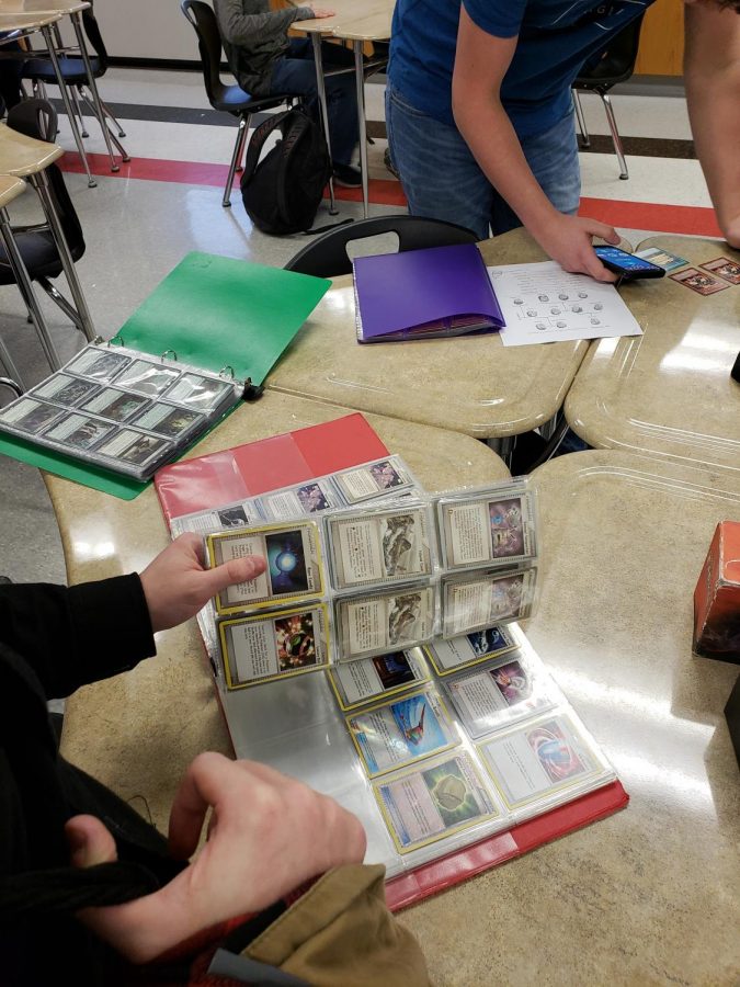 Ryan Forcey looking through Pokemon cards in Card Club, which meets during Activity Period.