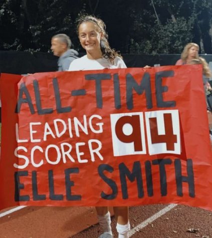 Elle holds the poster that celebrates her record-breaking goal. 