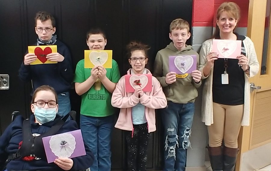 Ms. Plyer, far right, poses with her students who recently created Valentines for a local retirement center.