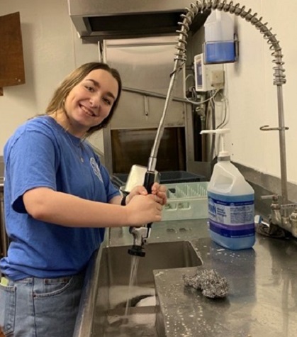 Rylee Ogden helps clean up at a recent community event.